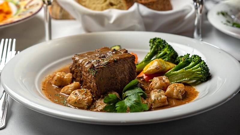 Steak entree with side of potatoes and vegetables