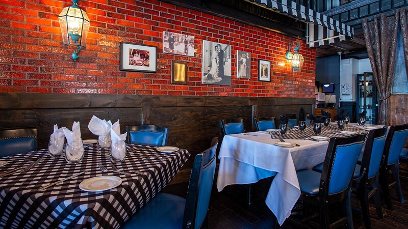 Dining room with set tables against brick wall